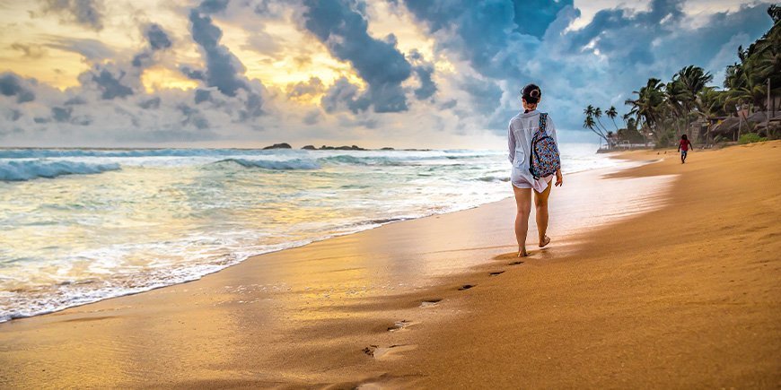 Woman walks on beach in Sri Lanka