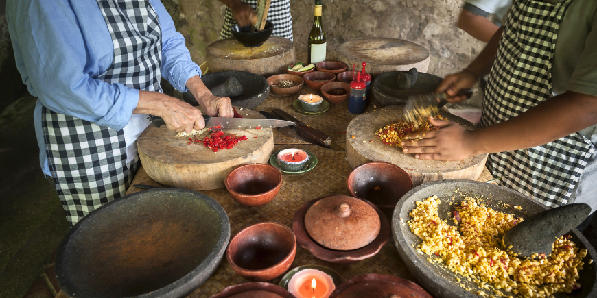 Student by teacher during Balinese cookery class