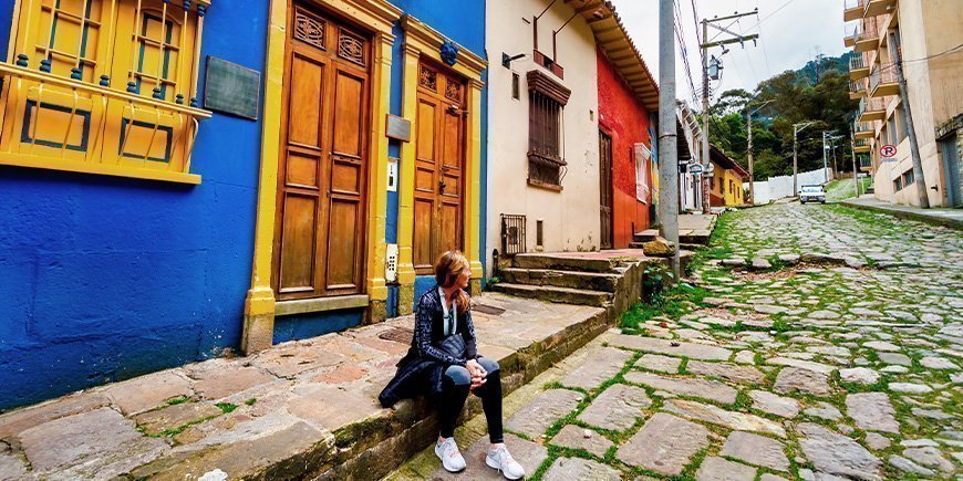 Woman sitting on the street in La Candelaria in Bogotá, Colombia