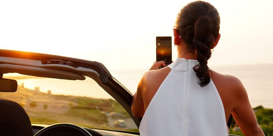 Woman taking a picture of sunset in Australia