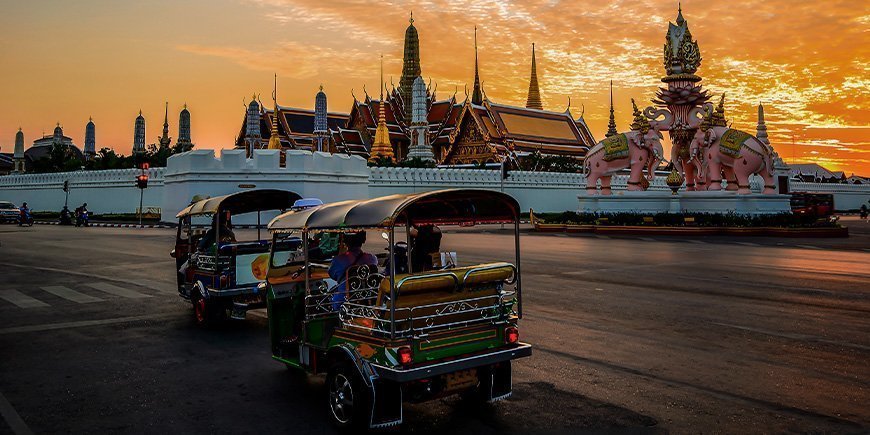 Tuk Tuk with a view of a temple in Bangkok