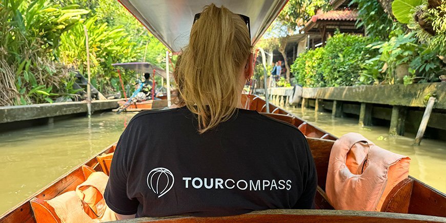 Woman in TourCompass t-shirt sitting in boat with her back turned