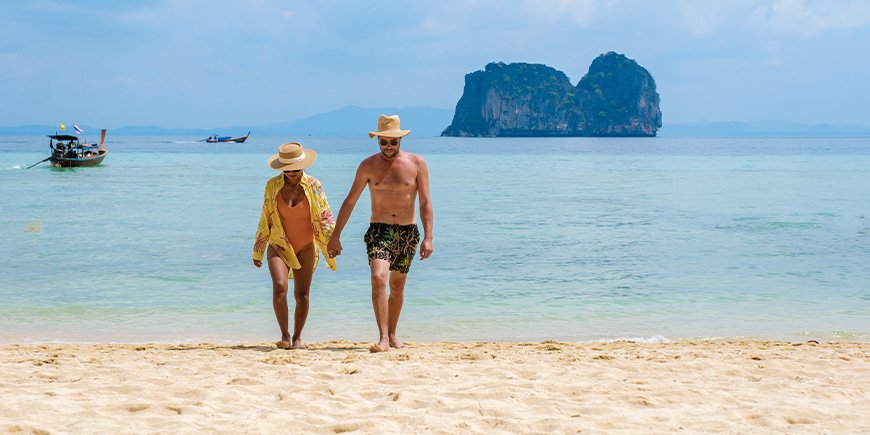 Couple walking on the beach on Koh Ngai island in Thailand