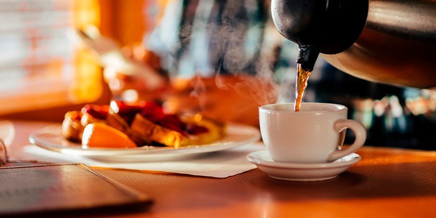 Man sitting in diner eating waffles and drinking coffee