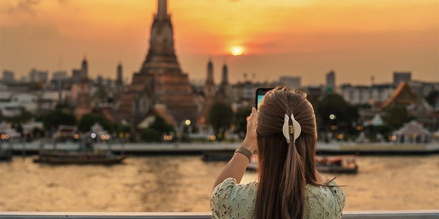 Woman takes photo of Wat Arun in Bangkok