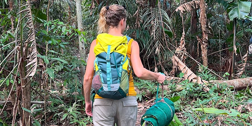 Jude hiking with her sleeping bag in the Amazon jungle