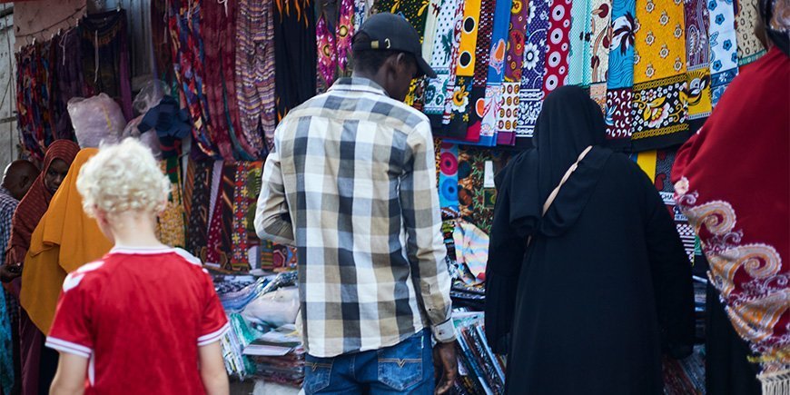 Boy walking among the locals at the market in Stone Town