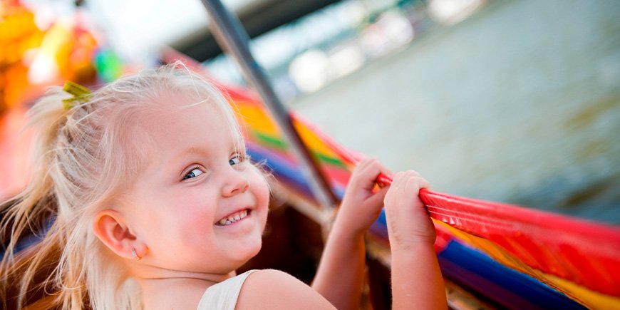 Smiling girl sitting on a boat on the Chao Praya River in Thailand