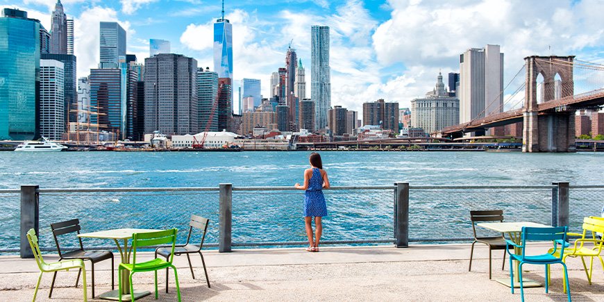 Women in summer dresses looking at the New York skyline